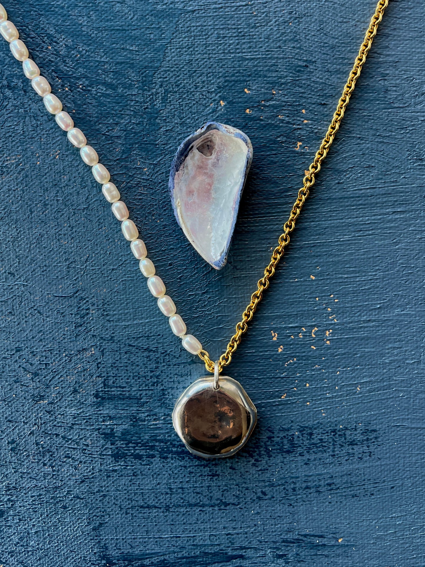 Domed pendant on a pearl and gold chain necklace